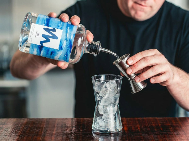 Pouring a measure of Millsheds gin over ice at the bar